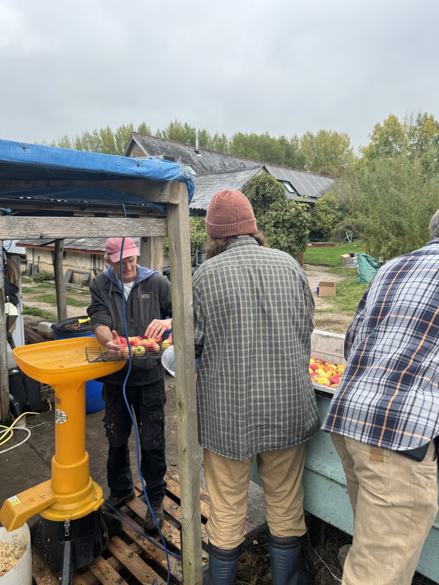 Two people working an apple press at the farm