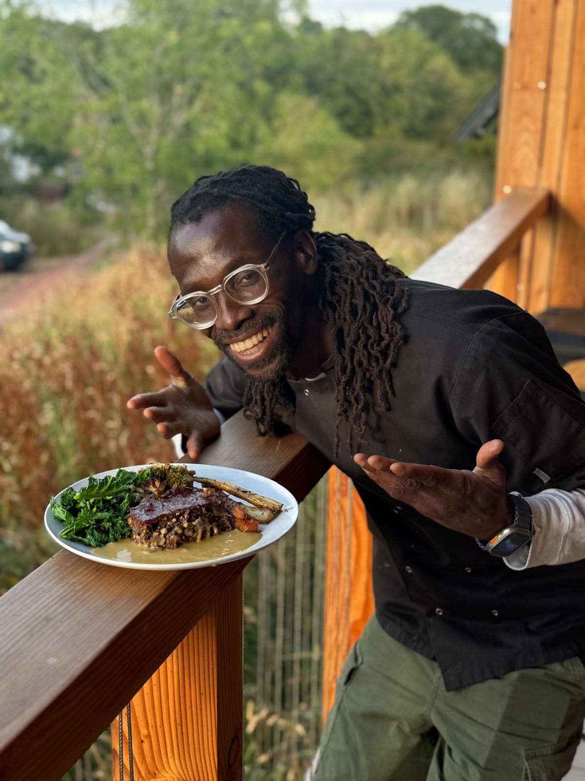 Kwame Afrik holding a plate of freshly prepared food