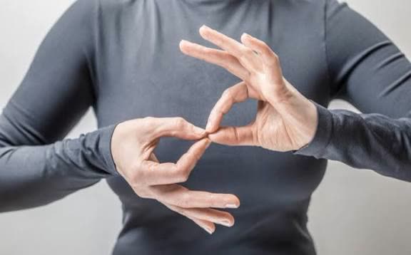 Close‑up of hands forming a British Sign Language sign
